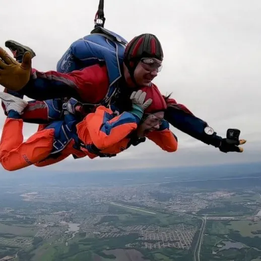 Небо и облака: тандемный прыжок с парашютом над живописным ландшафтом в ясный день