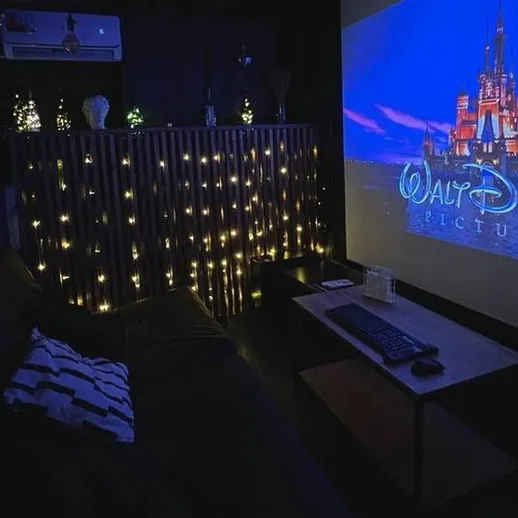 Уютный кинозал с мягким диваном и проекцией Уолта Диснея в темном помещении