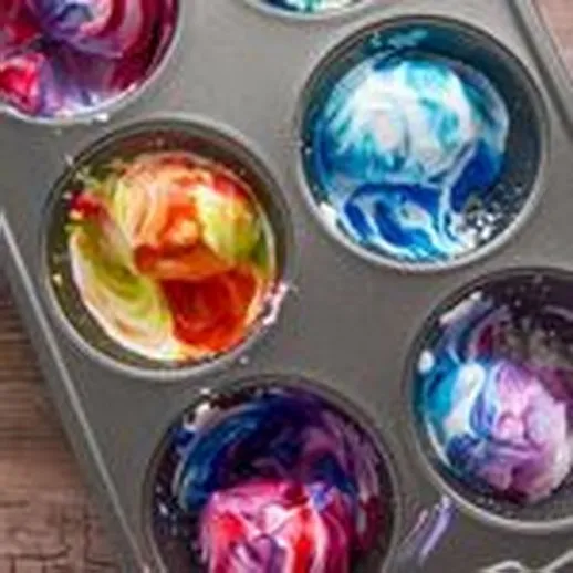 Яркие цветные мраморные шары в форме для выпечки на деревянной поверхности