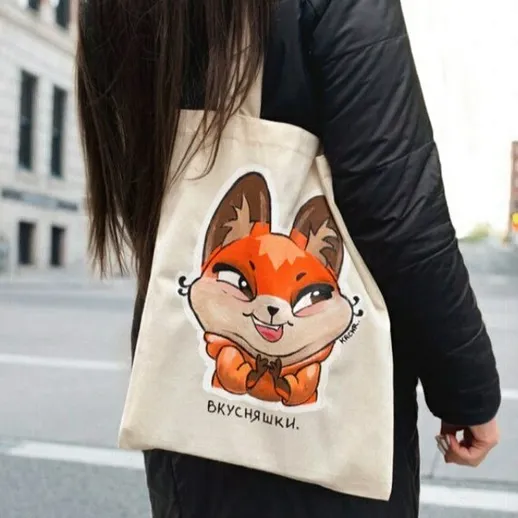 Элегантная женщина с сумкой, украшенной милой лисичкой, на улице города в ясный день