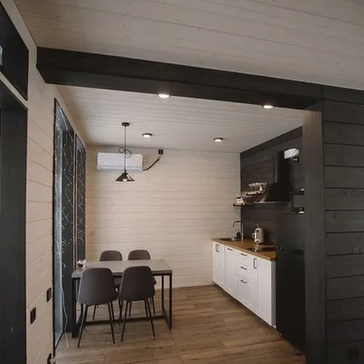 Уютная современная кухня в загородном доме с обеденной зоной и деревянным полом