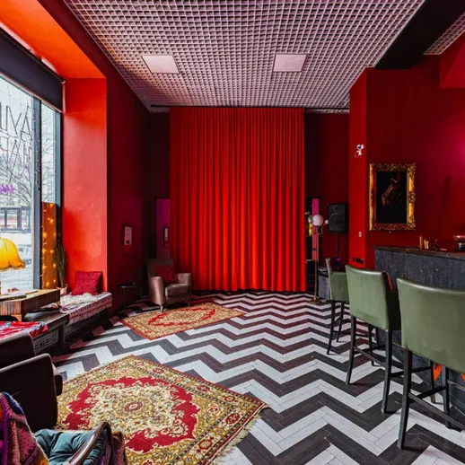 Уютный интерьер бара с красными стенами и зебровым полом в центре города
