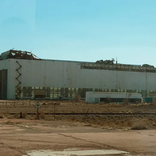 Заброшенное здание с разрушенной крышей в пустынной местности во время солнечного дня