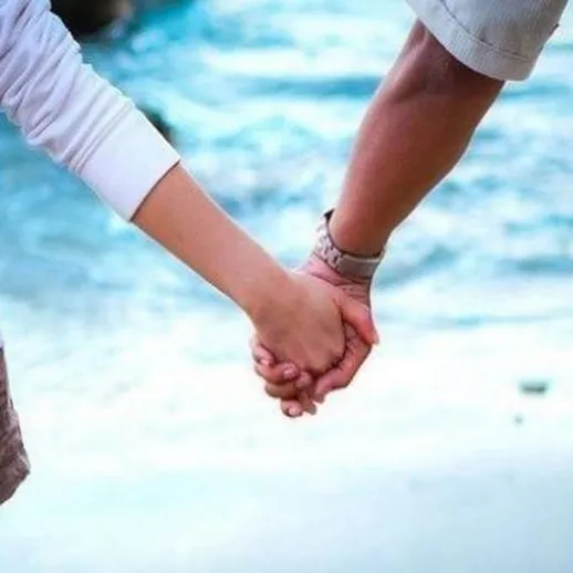 Романтическая прогулка влюбленной пары по пляжу рядом с морем в теплый летний день