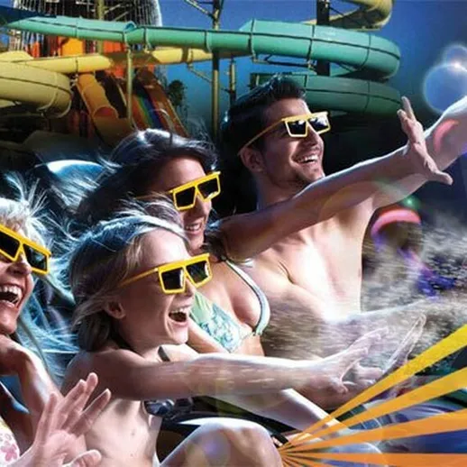 Люди в ярких очках наслаждаются аттракционом в аквапарке летом, испытывая удовольствие и веселье на водных горках