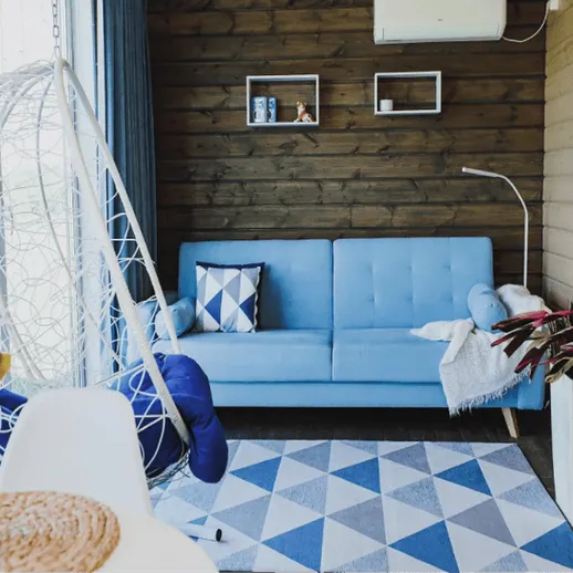 Комфортный интерьер уютной комнаты с синим диваном и современным декором в стиле минимализма