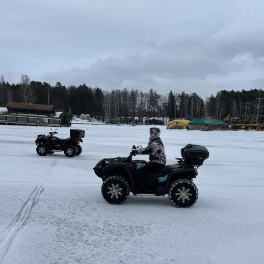 Катание на квадриках по заснеженной площади в лесу