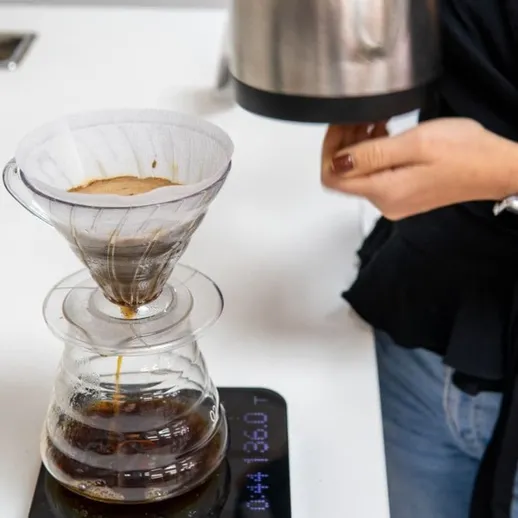 Приготовление кофе с помощью воронки на кухне с белым интерьером