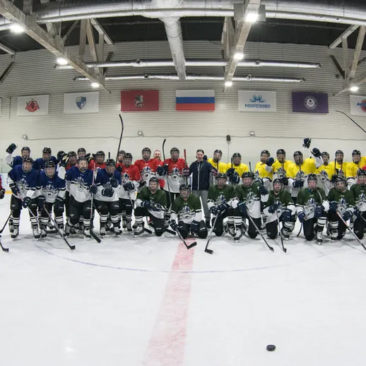 Командное фото хоккеистов на льду спортивного комплекса во время тренировки в теплое время года