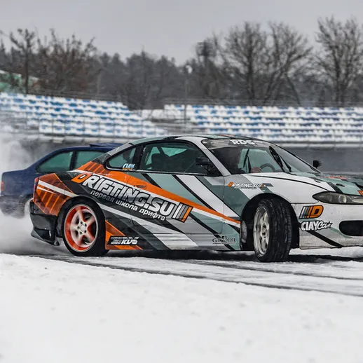 Дрифт на снегу с использованием спортивных автомобилей на гоночной трассе в зимний день