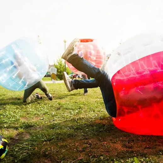 Участники весело катятся в шарах на семейном празднике в парке в солнечный день