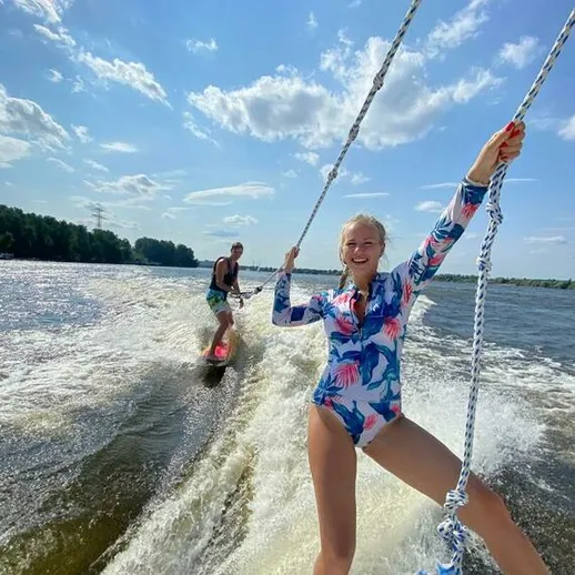 Девушка на водных лыжах наслаждается летом на канале у искусственного озера