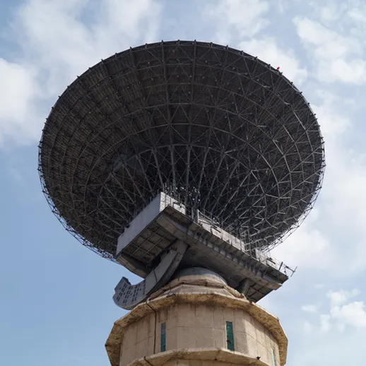 Большая антенна радиолокационной станции на фоне голубого неба в ясный день