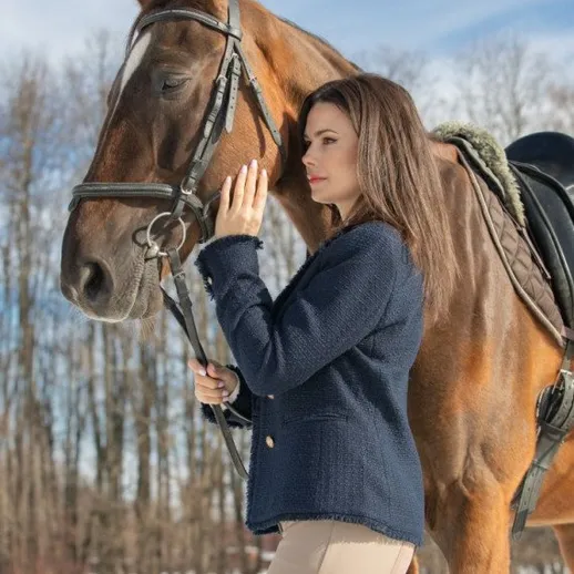 Женщина ведет лошадь по снежному полю в зимний день