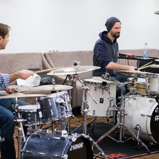 Два музыканта репетируют на ударных инструментах в студии звукозаписи в осенний вечер