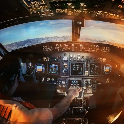 Пилот управляет самолетом в закатное время над горами