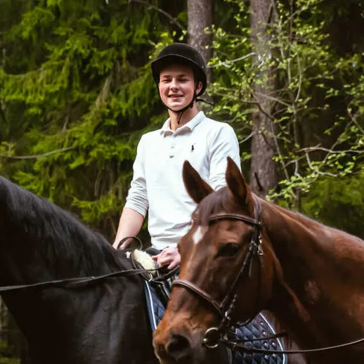Парень на лошади в лесу наслаждается верховой ездой и природой в солнечный день осенью Парень на лошади в лесу наслаждается верховой ездой и природой в солнечный день осенью