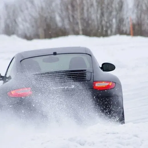 Зимние гонки на черном спортивном автомобиле по снежным трассам в северной местности