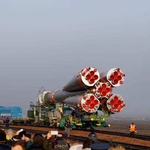 Запуск ракеты на космодроме в ясное утро, зрители наблюдают за подготовкой к старту