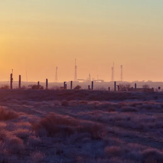 Закат над степью с башнями связи на горизонте в Казахстане