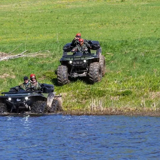 Операция на внедорожниках в водоеме на зеленом лугу в ясный солнечный день