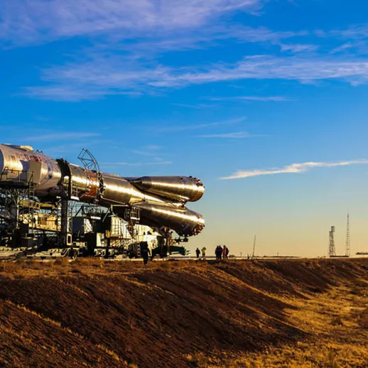 Запуск ракеты на космодроме в предвечернее время под ясным небом с яркими облаками