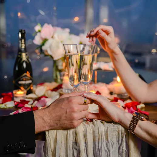 Романтический ужин при свечах с шампанским и цветами на столе