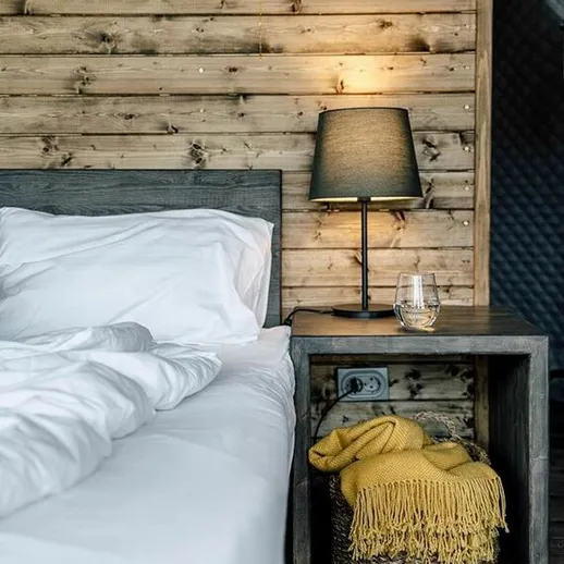 Уютная спальня с деревянными стенами и мягким освещением в загородном доме