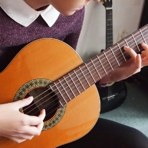 Игра на гитаре в уютной комнате с мягким освещением и гитарой