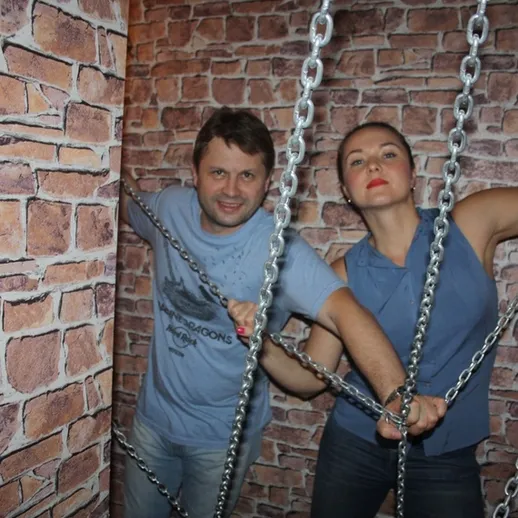 Мужчина и женщина в цепях на фоне кирпичной стены в творческой студии