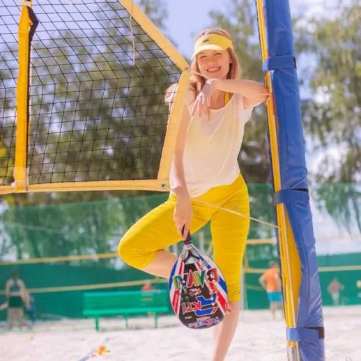 Молодая девушка на пляже с мячом для волейбола, готовится к игре в солнечный день