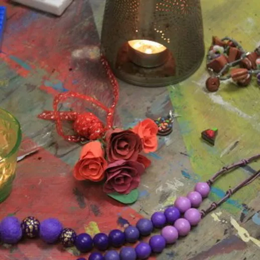 Креативный стол с рукодельными украшениями, свечами и цветами в уютном пространстве