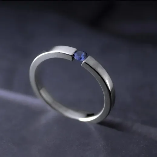 Простое металлическое кольцо с изысканным дизайном на фоне темной поверхности